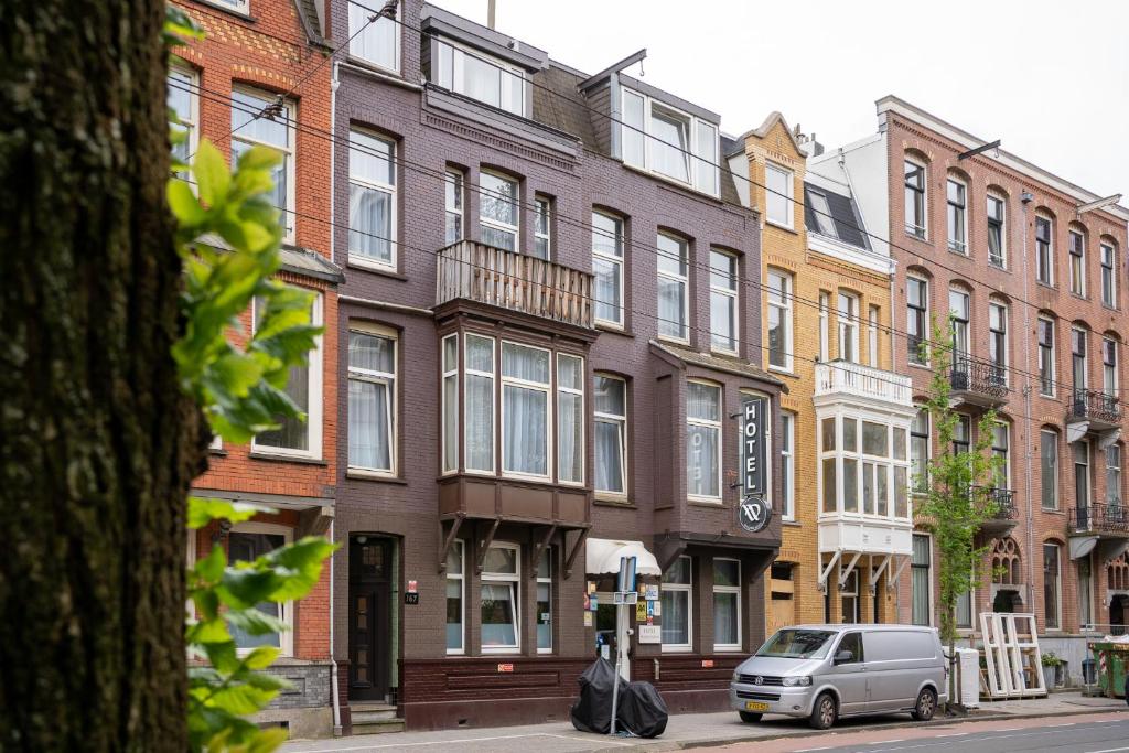 a van parked in front of a row of buildings at Aadam Hotel Wilhelmina in Amsterdam