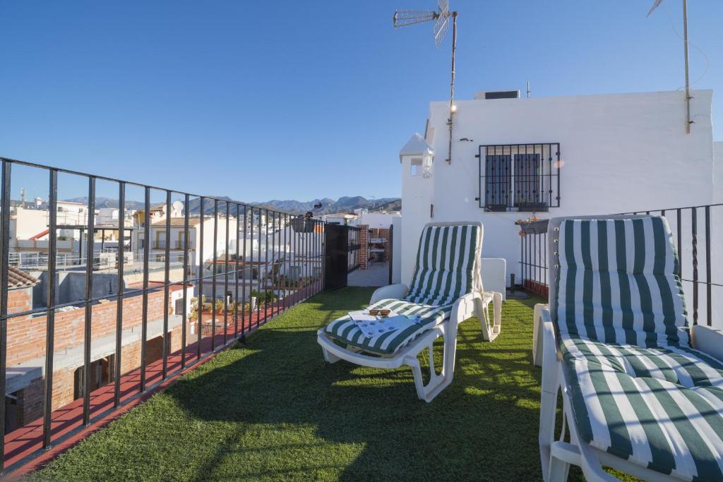 dwa krzesła siedzące na balkonie w obiekcie Atico Jimena Granada en el centro de Nerja w mieście Nerja