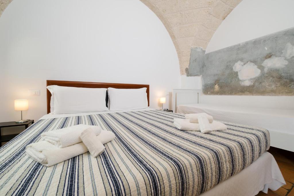 a bedroom with a bed with towels on it at Masseria Borgo Santuri in Ostuni