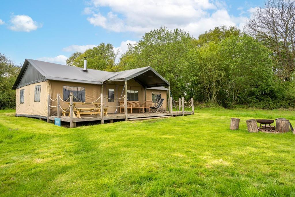 a luxury tent in a field with a yard at Swift - Sweffling Hall in Rendham