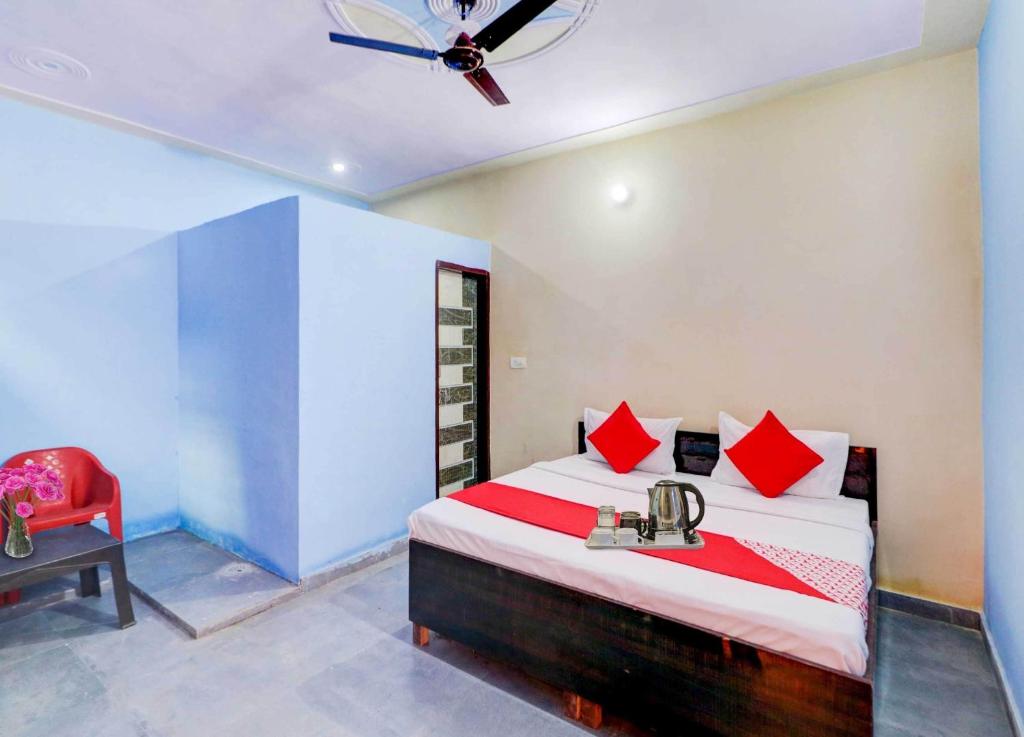 - une chambre avec un lit et une chaise rouge dans l'établissement OYO Flagship 81042 Hotel Royal Inn, à Manesar