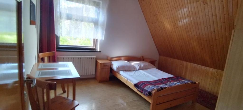 una piccola camera con letto e tavolo di Noclegi Beskidzkie a Korbielów