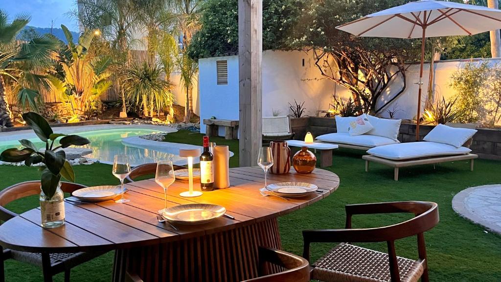 - une table en bois avec des verres à vin sur la terrasse dans l'établissement Chez Pim's, à Hyères