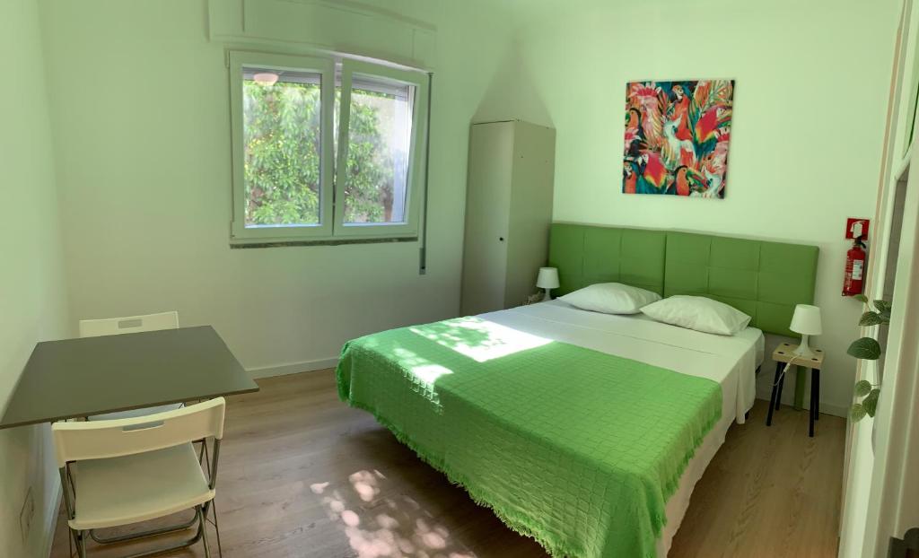 Schlafzimmer mit einem Bett, einem Schreibtisch und einem Fenster in der Unterkunft Ciao Tavira in Tavira