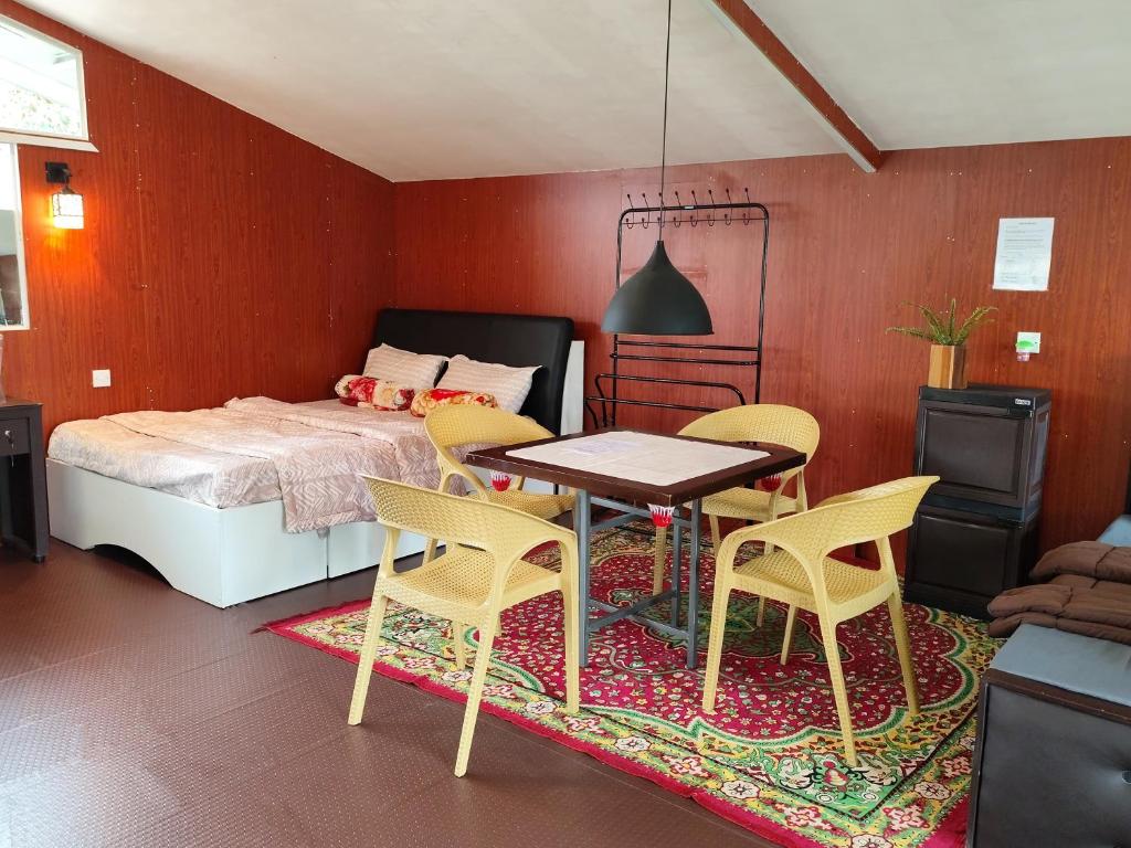 um quarto com uma cama, uma mesa e cadeiras em Townside Lodge em Nuwara Eliya