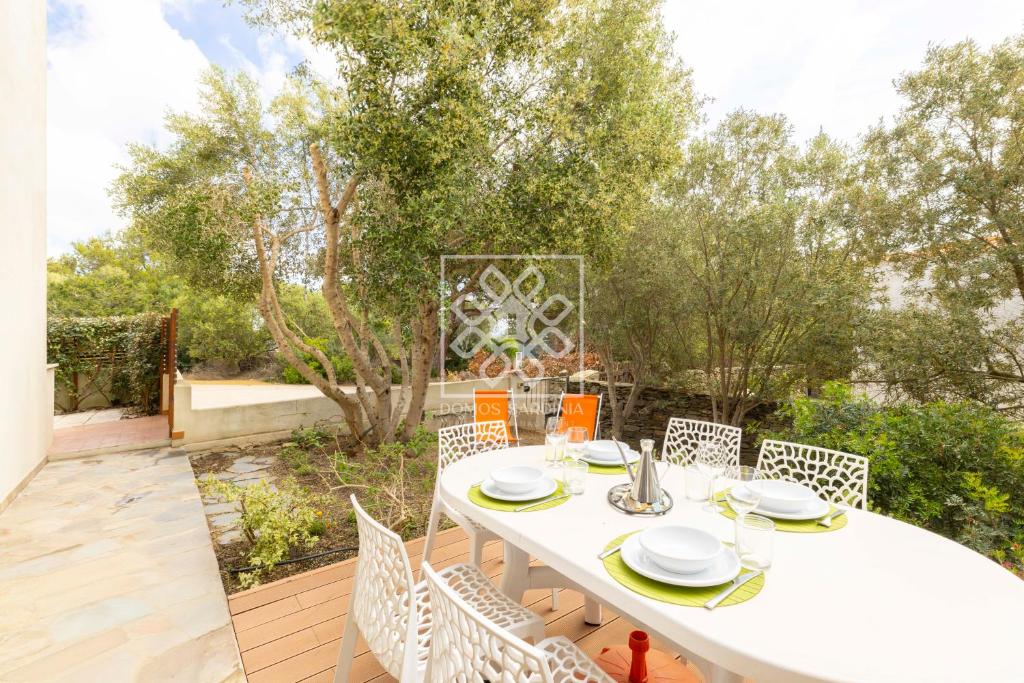 a white table and chairs on a patio at Isthintini-Parcheggio gratuito in Stintino