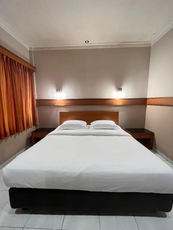 Postel nebo postele na pokoji v ubytování Hotel Caravan Tanah Abang