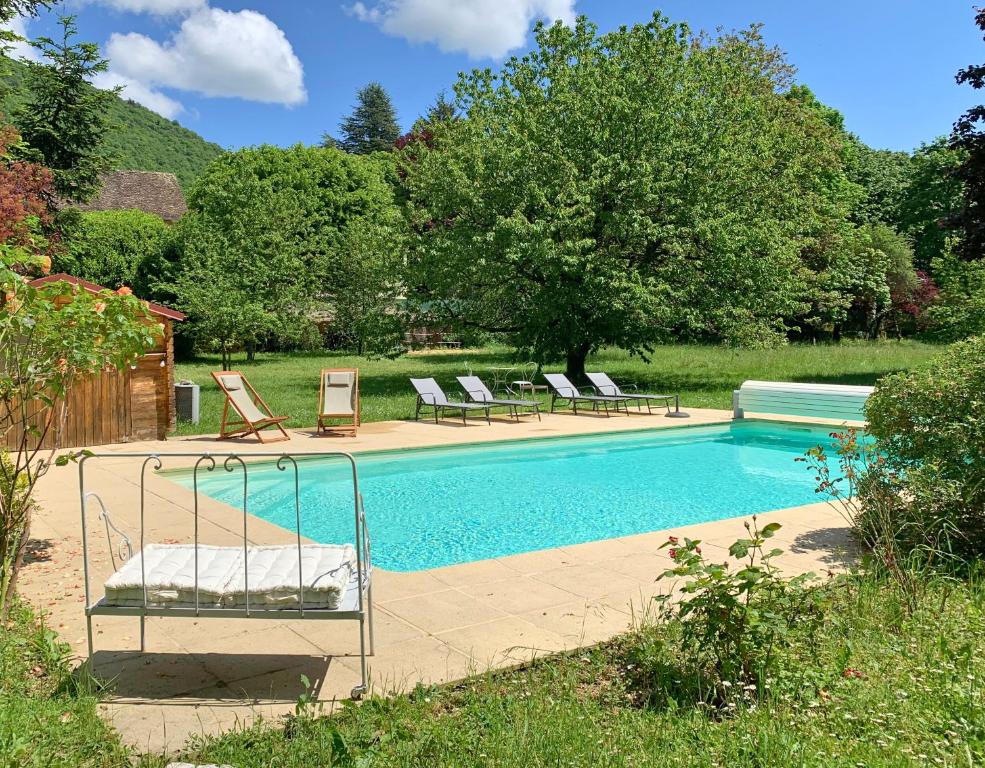 a swimming pool with two lounge chairs next to it at Maison d'hôtes et gîte de charme avec piscine, La Lhuiseraie in Lhuis