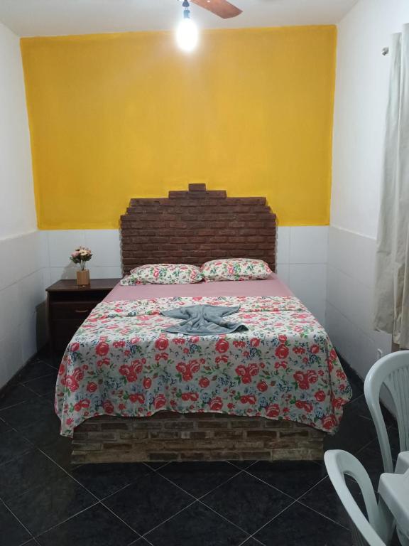 1 dormitorio con 1 cama con manta roja y pared amarilla en Pousada Villa do Mar, en Itaparica
