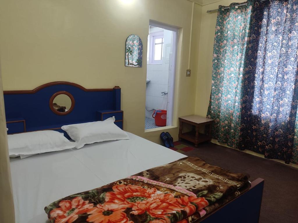 a bedroom with a bed with a blue headboard and curtains at Dal Point view in Srinagar