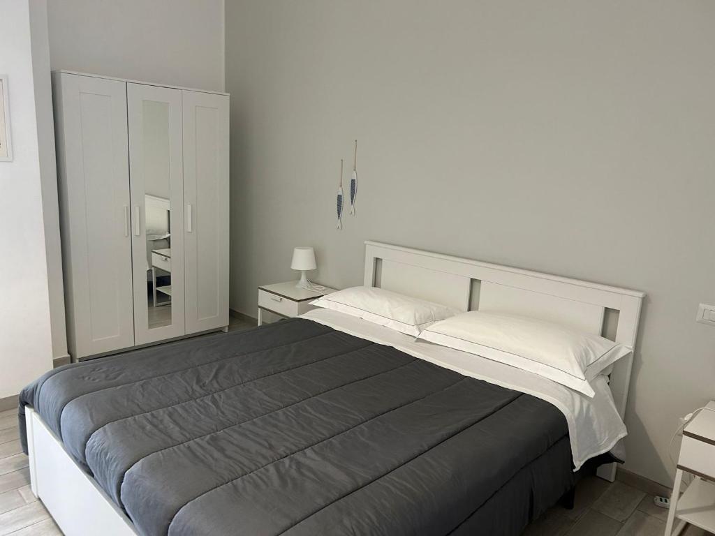 een slaapkamer met een groot bed en een spiegel bij SoleeMare Barletta Apartments in Barletta