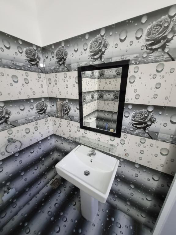 y baño con lavabo y espejo. en Nilaveli Guest House, en Nilaveli