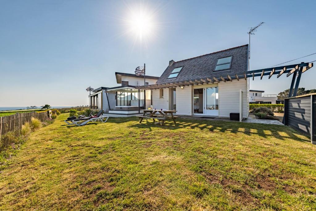 uma casa com um grande quintal em frente em La Maison Des Gardiens De L'océan - em Plougonvelin