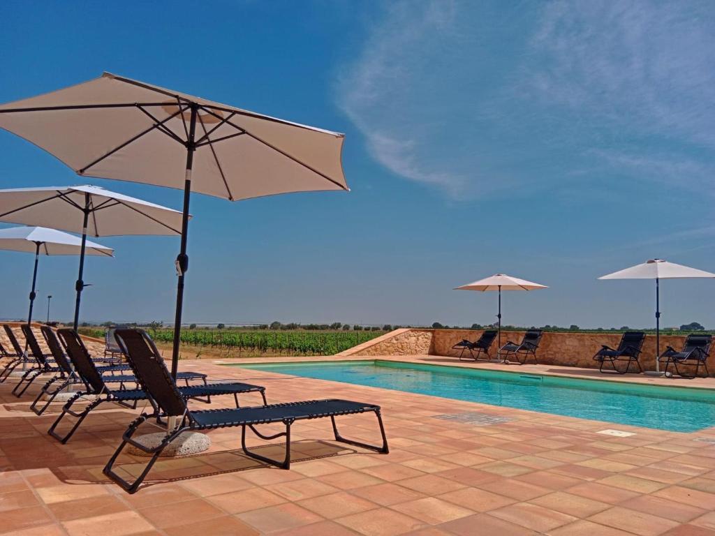 a group of chairs and umbrellas next to a swimming pool at Vigna di pettineo - guest house in Vittoria