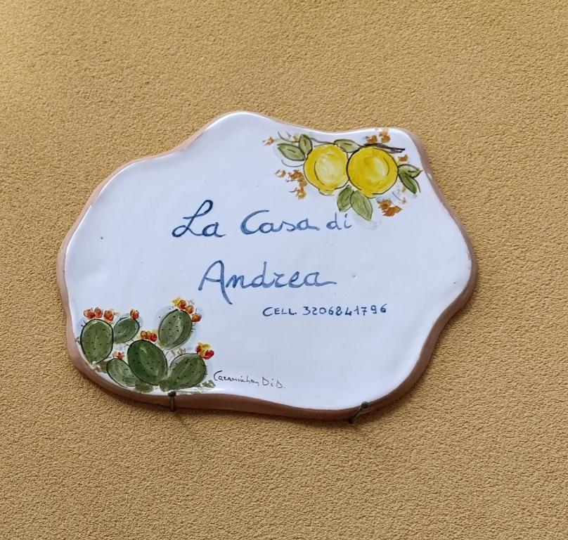 een bord met een bord op een muur bij La casa di Andrea in Terrasini
