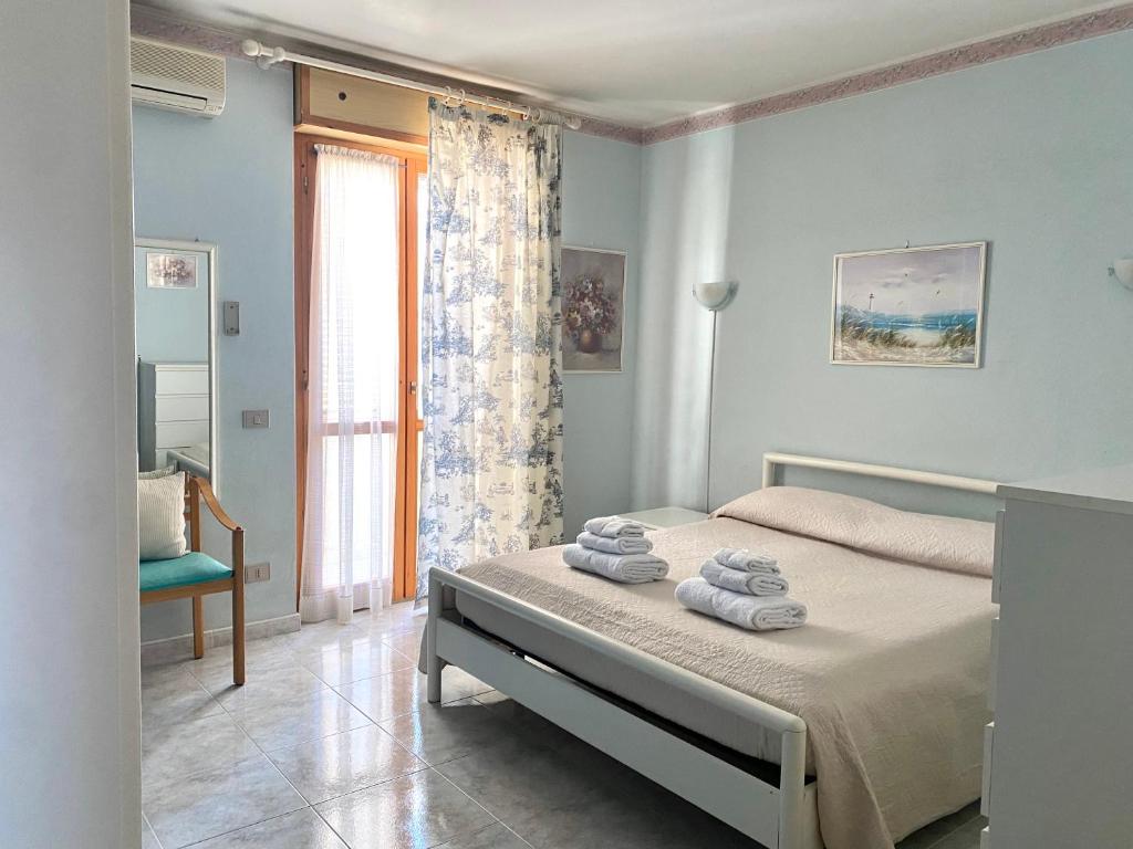 una camera da letto con un letto con asciugamani sopra di La Tana Alghero ad Alghero