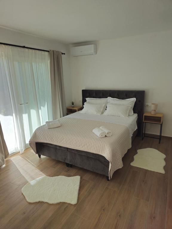 een slaapkamer met een groot bed met twee tapijten op de vloer bij Apartman Marija in Baška Voda
