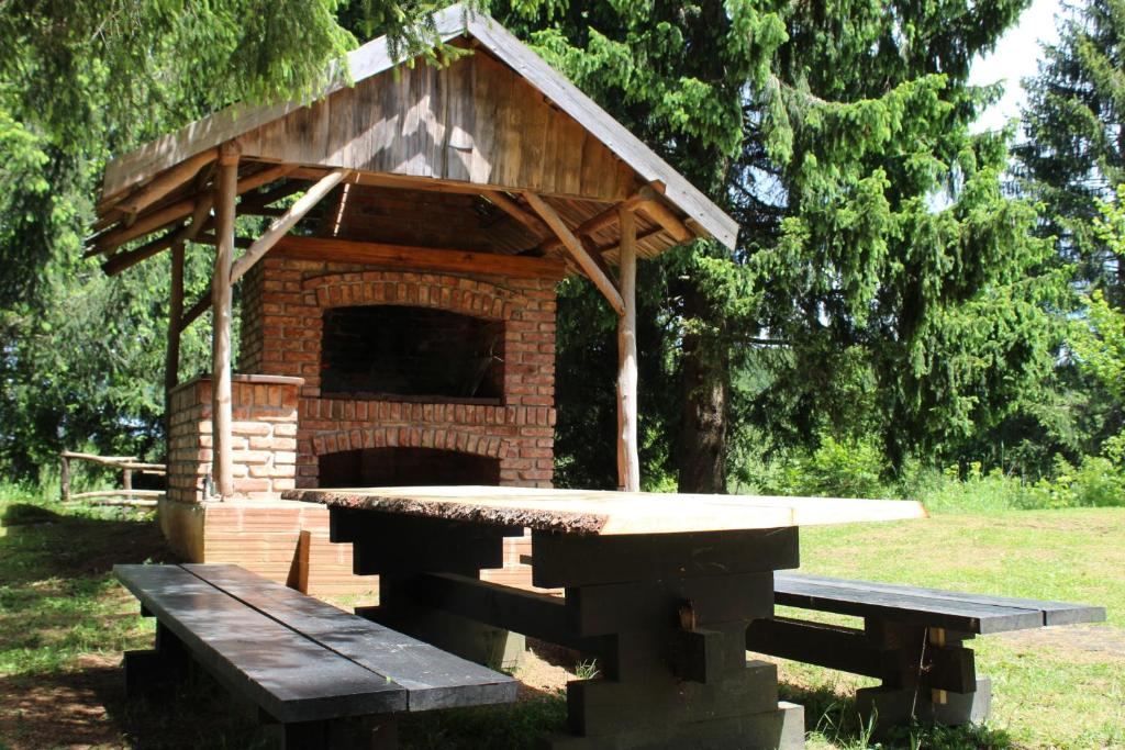 a picnic table and a brick barbecue grill with a bench at Vacation House Home, Plitvice Lakes National Park in Plitvička Jezera