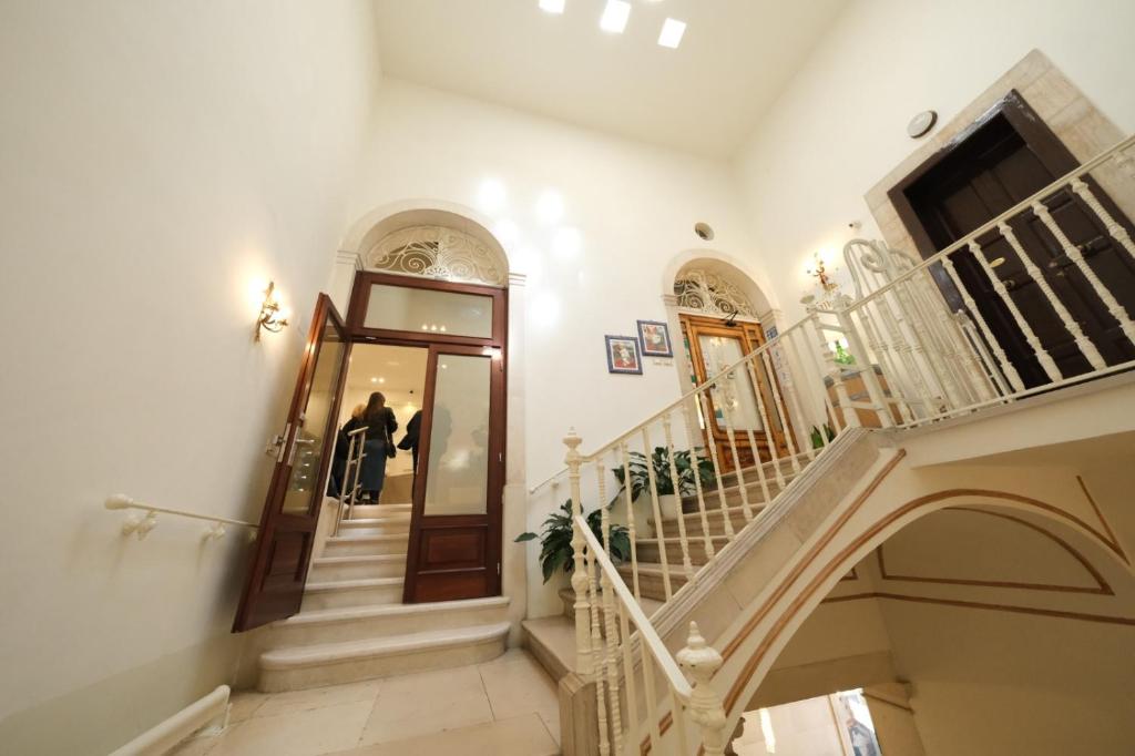 a person walking down a staircase in a house at Principe Boemondo Luxury Room in Canosa di Puglia