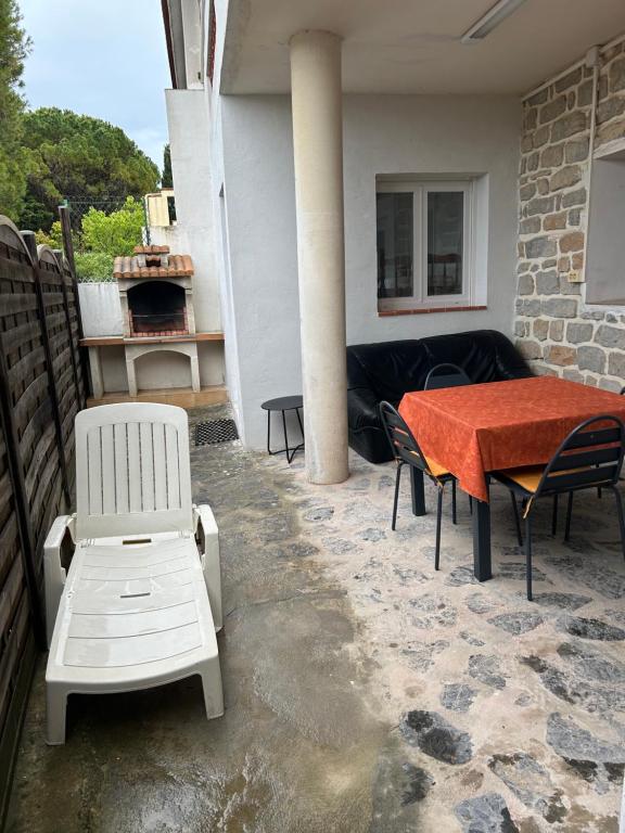 un patio avec une table, des chaises et un canapé dans l'établissement Sirmione, à Leucate