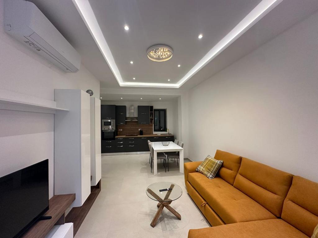 a living room with a couch and a table at Acacia Avenue Apartments in Is-Swieqi