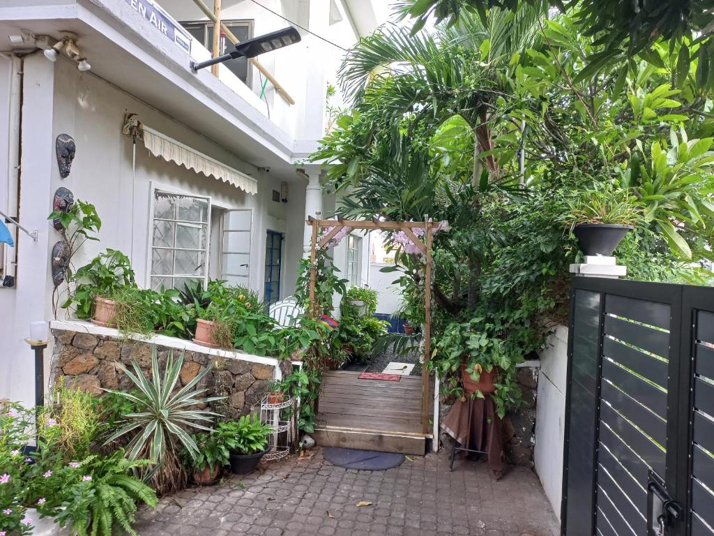 uma entrada de jardim para uma casa com plantas em Open Air Café & Apartment 1 em Port Louis