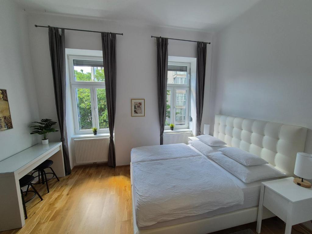 biała sypialnia z łóżkiem i biurkiem w obiekcie Sweet Dreams w Wiedniu