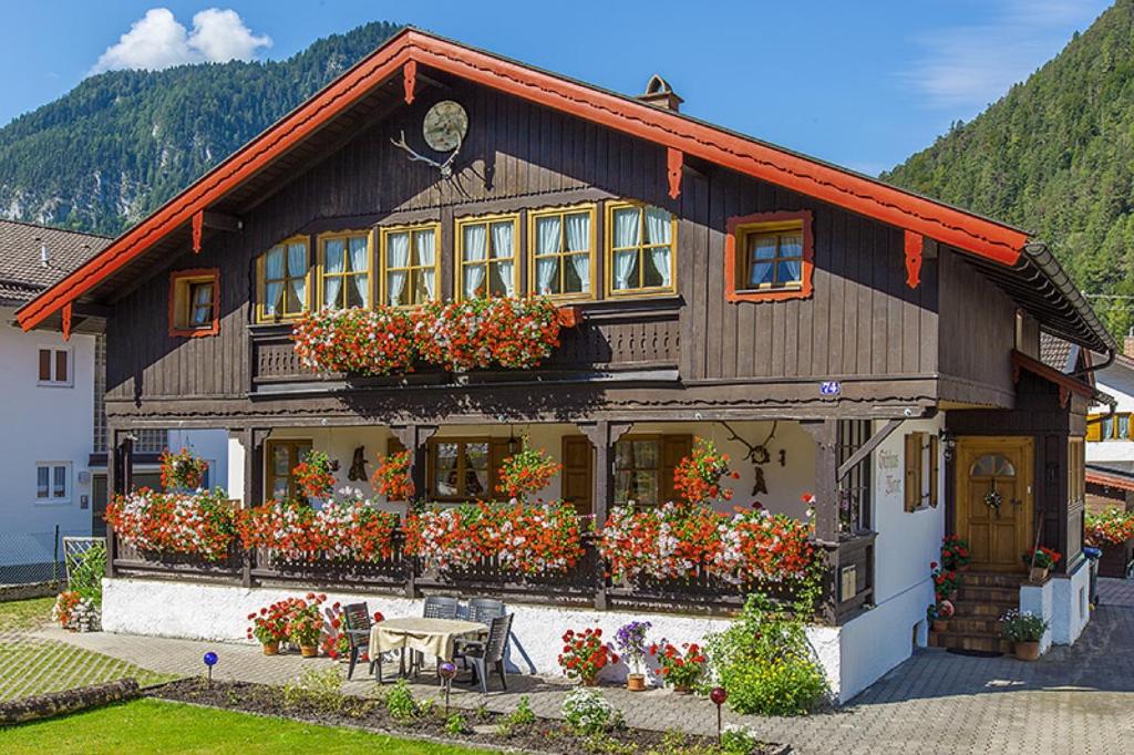 a house with lots of flowers in front of it at Ferienwohnungen Weiß in Mittenwald