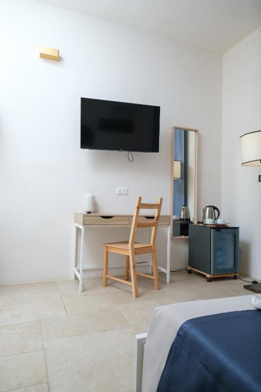 a room with a desk and a chair and a tv at Masseria Borgo Santuri in Ostuni