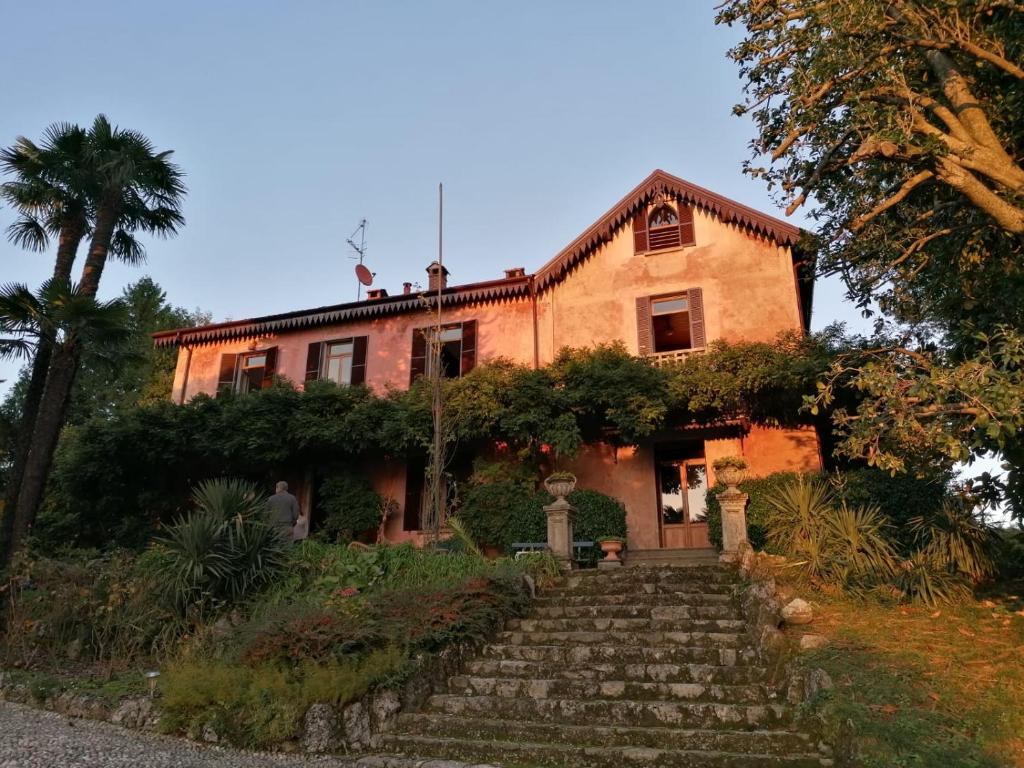 une vieille maison avec des escaliers en face de celle-ci dans l'établissement Casa della Gioia, à Castelveccana