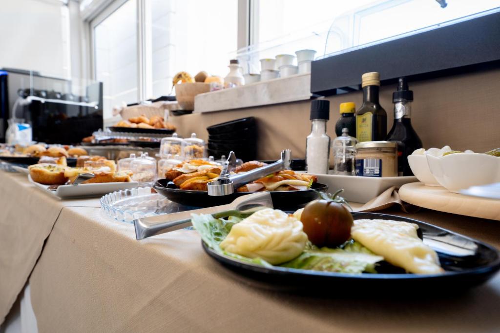 a buffet with plates of food on a table at Neko Boutique Hotel in Cagliari