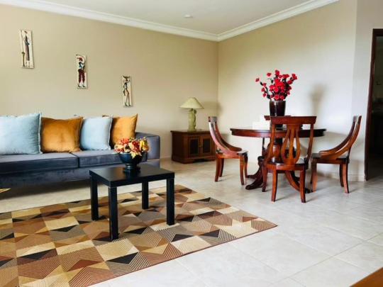 salon z kanapą i stołem w obiekcie Seafront Residences & Hotel w mieście Bijilo