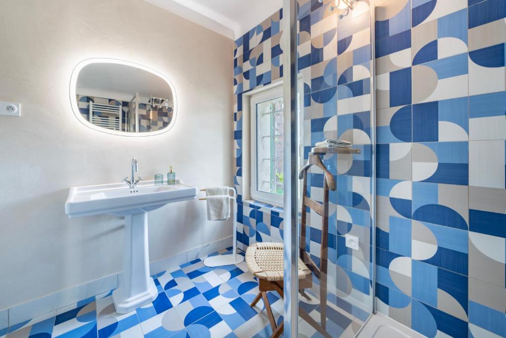 a blue and white bathroom with a sink and a shower at Domaine des Encourdoules in Vallauris
