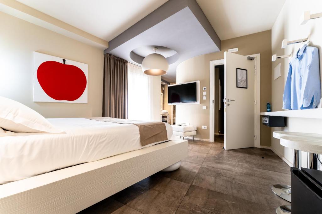 a bedroom with a bed with a red apple painting on the wall at Neko Boutique Hotel in Cagliari