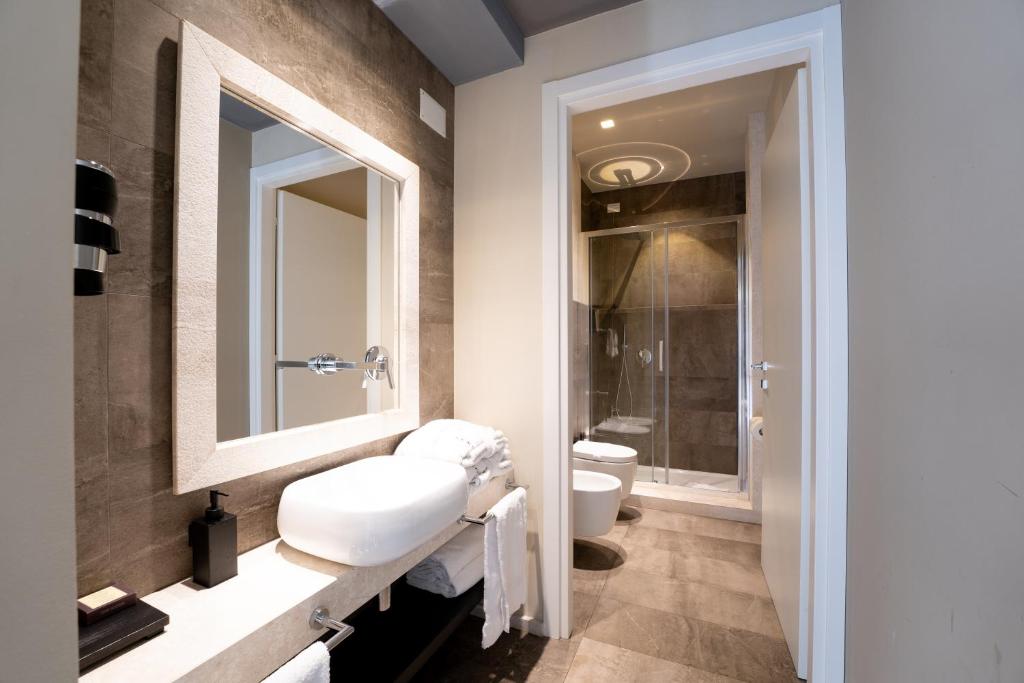 a bathroom with a sink and a toilet at Neko Boutique Hotel in Cagliari