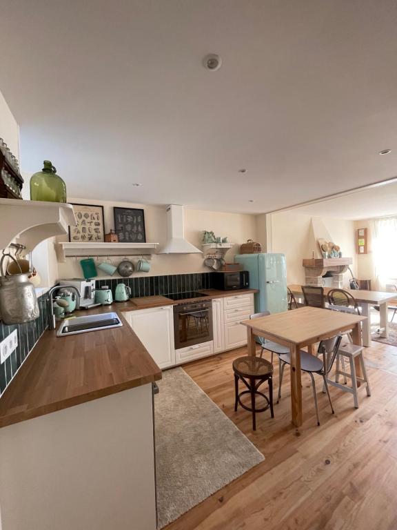 een keuken met een tafel en een eetkamer bij -Les Petites Planches- Gîte Familial entre Terre & Mer in La Haye-Pesnel