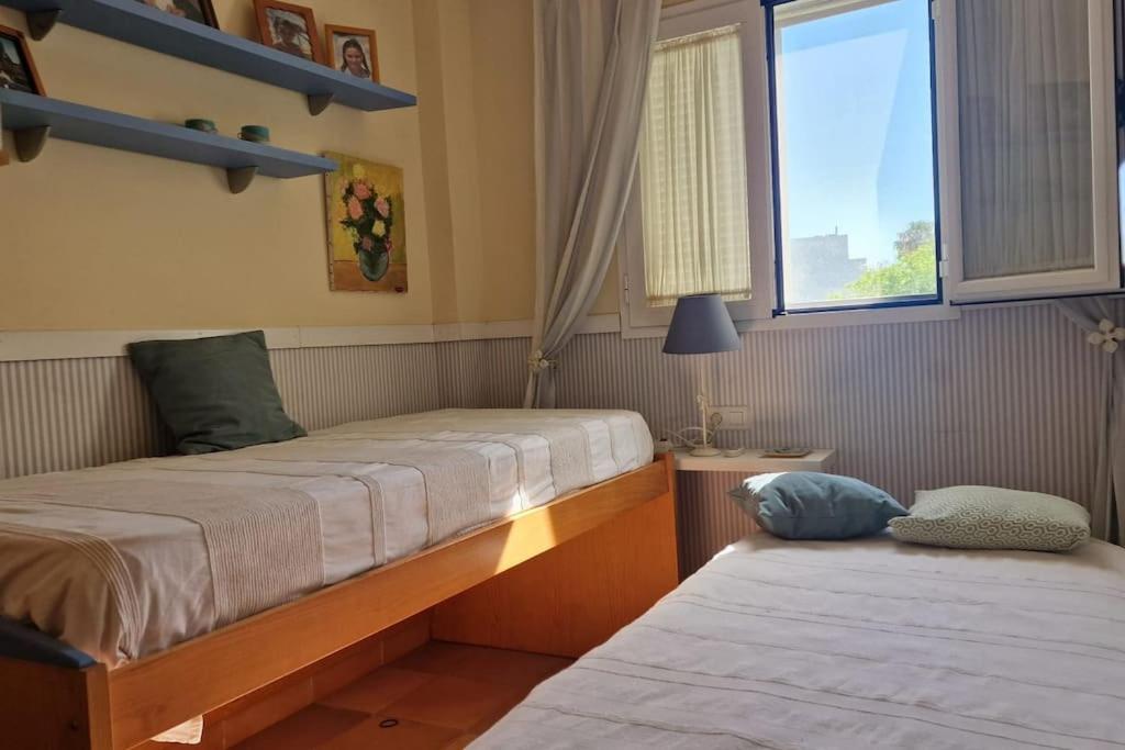 Dos camas en una habitación con ventana. en Galia Ballena (Rota) - Carlos, en Costa Ballena