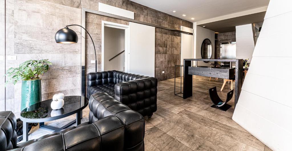 a living room with a leather couch and a table at Neko Boutique Hotel in Cagliari