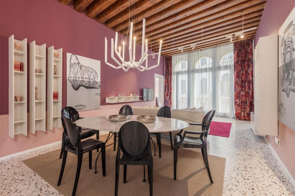 ein Esszimmer mit lila Wänden, einem Tisch und Stühlen in der Unterkunft Tadomo - Corte del Cafetier in Venedig