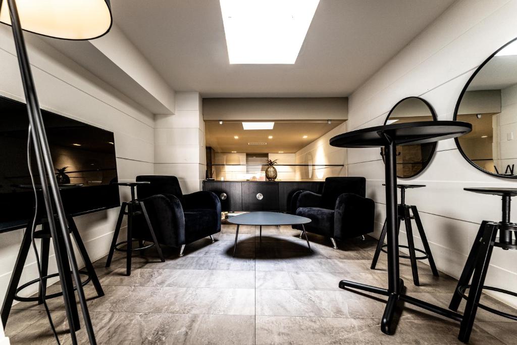 a salon with chairs and a table and a mirror at Neko Boutique Hotel in Cagliari