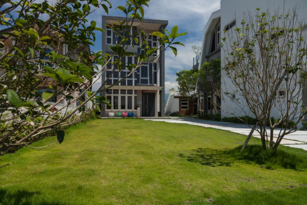 a grassy yard in front of a building at I Leisure B&amp;B in Yuanshan