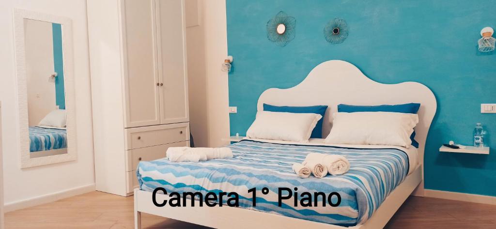 a bedroom with a bed with a blue wall at Vico 18 in Gaeta