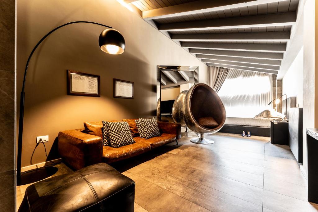 uma sala de estar com um sofá de couro e uma cadeira em Neko Boutique Hotel em Cagliari