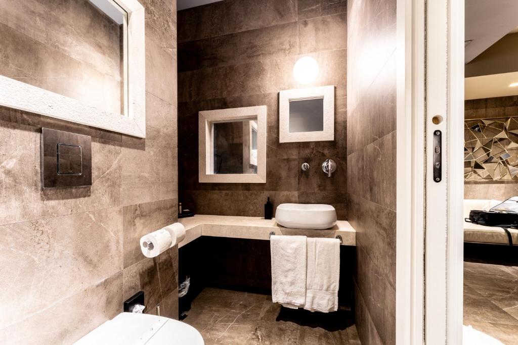 a bathroom with a sink and a toilet at Neko Boutique Hotel in Cagliari