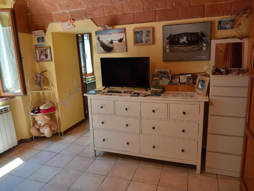 una stanza con un comò con una televisione di Casa Giulia on Francigena a Gambassi