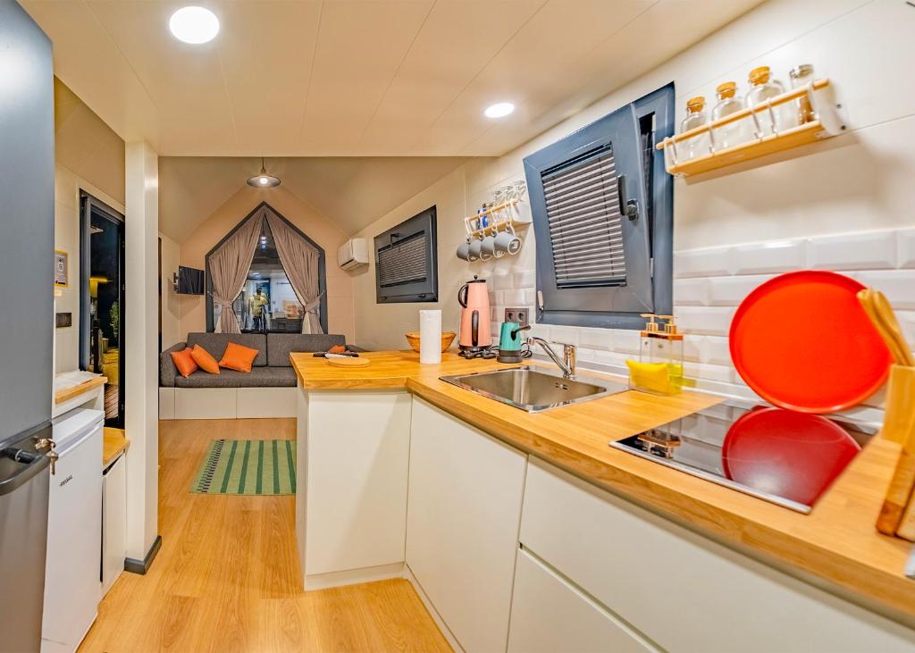 a kitchen with a sink and a red chair at Efe Tiny House in Serik