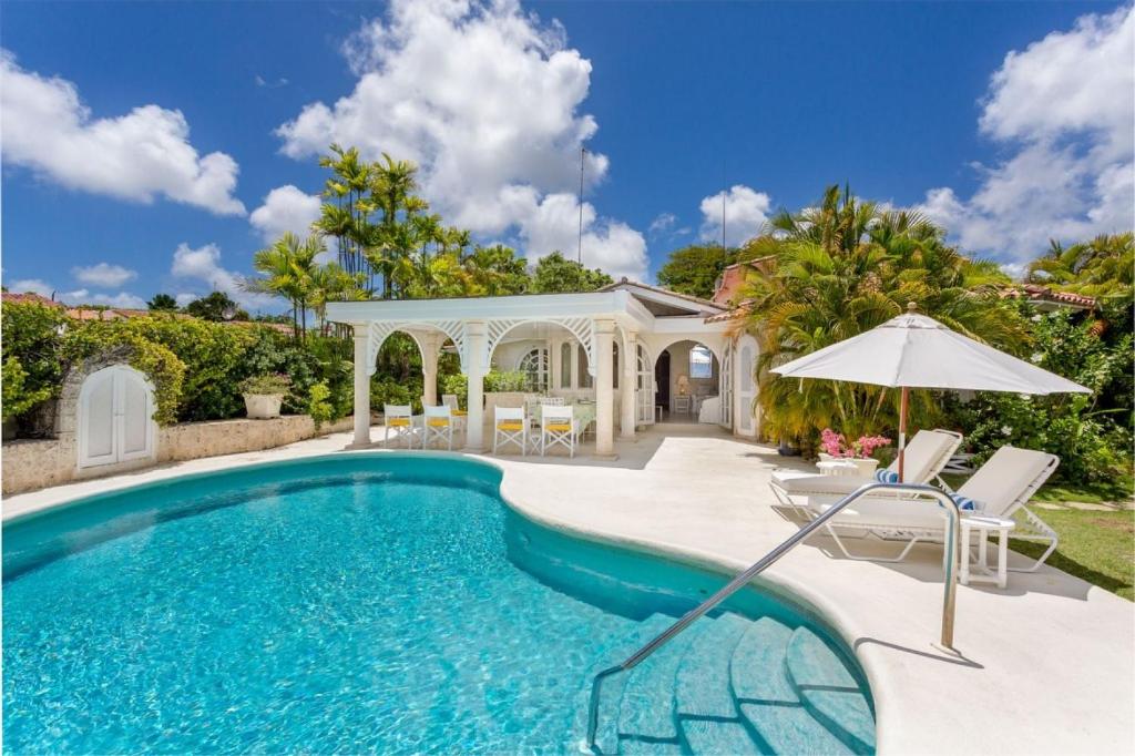 una piscina con cenador y sombrilla en Villa Whitegates, en Saint James