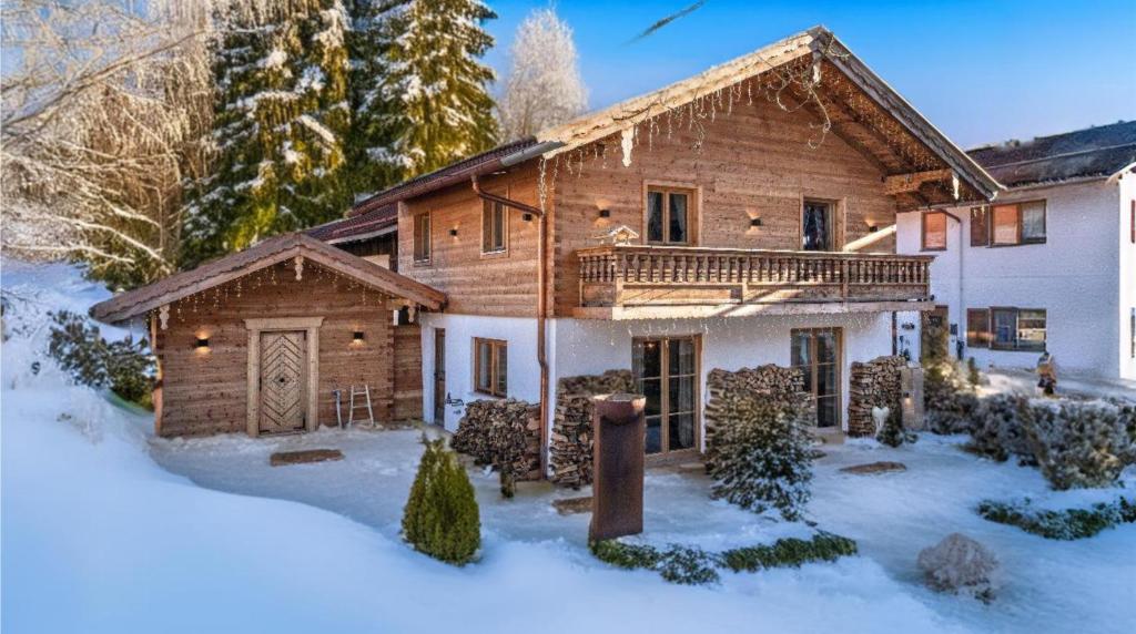 バイリッシュツェルにあるexklusives Alpenchalet mit Jacuzzi & Sauna für bis zu 14 Personenの雪の中にバルコニー付きのログハウス