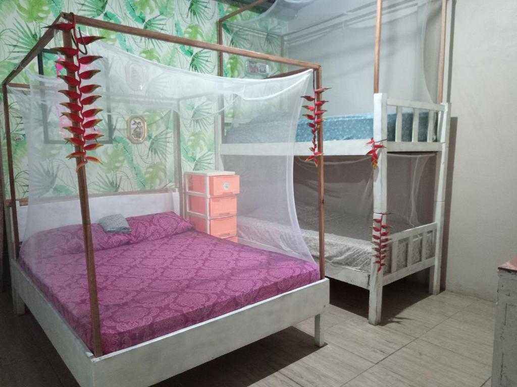 1 dormitorio con 2 literas con sábanas moradas en El Faro 13 de Puerto Viejo, en Puerto Viejo