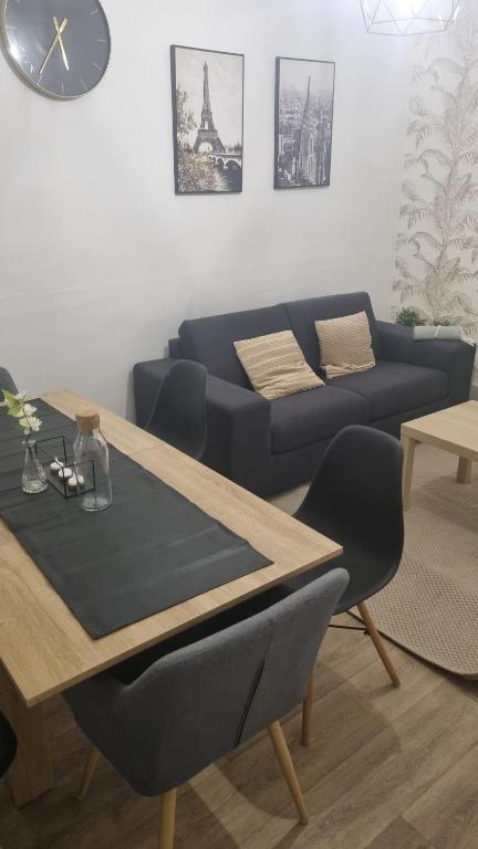 un salon avec un canapé bleu et une table dans l'établissement Maison Cocon, à Pantin